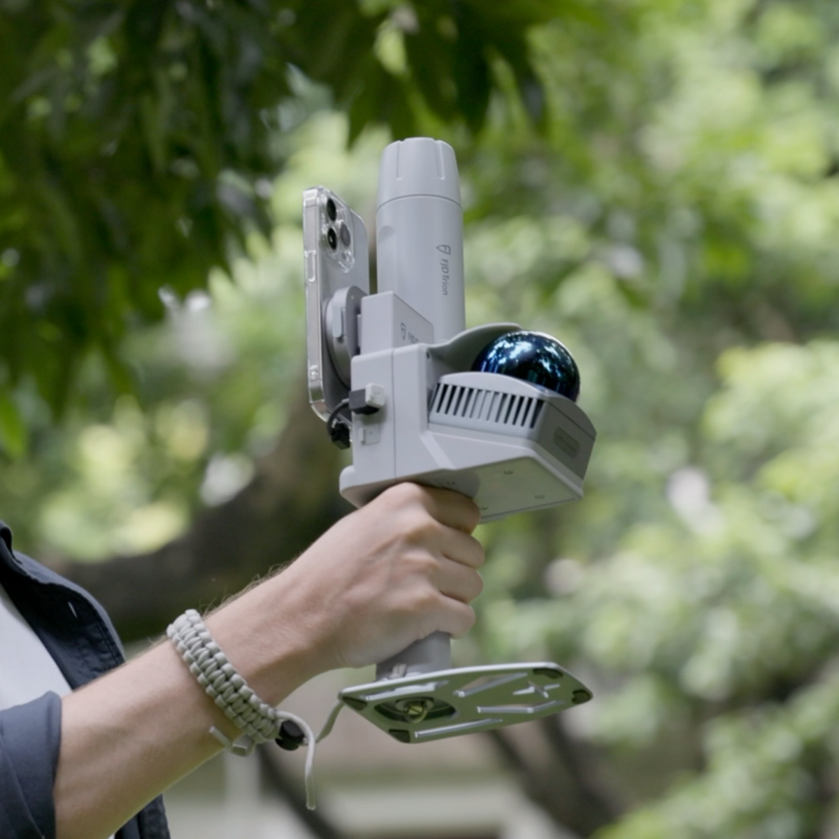 Close-up of operator holding a portable SLAM 3D scanner during field surveying
