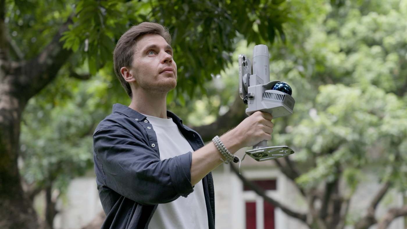 Close-up of operator holding a portable SLAM 3D scanner during field surveying